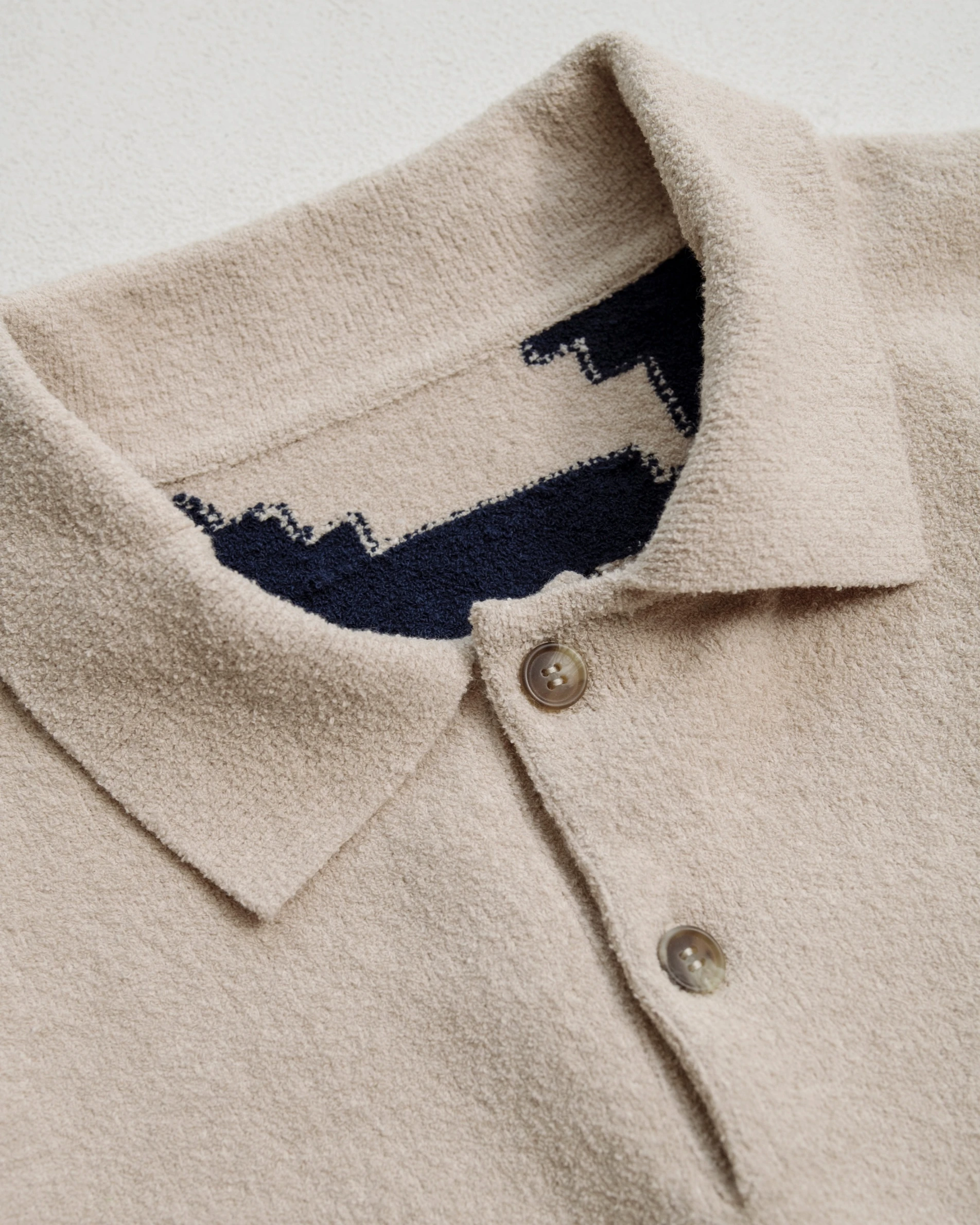 Collar detail of intarsia knitted polo sweater. 