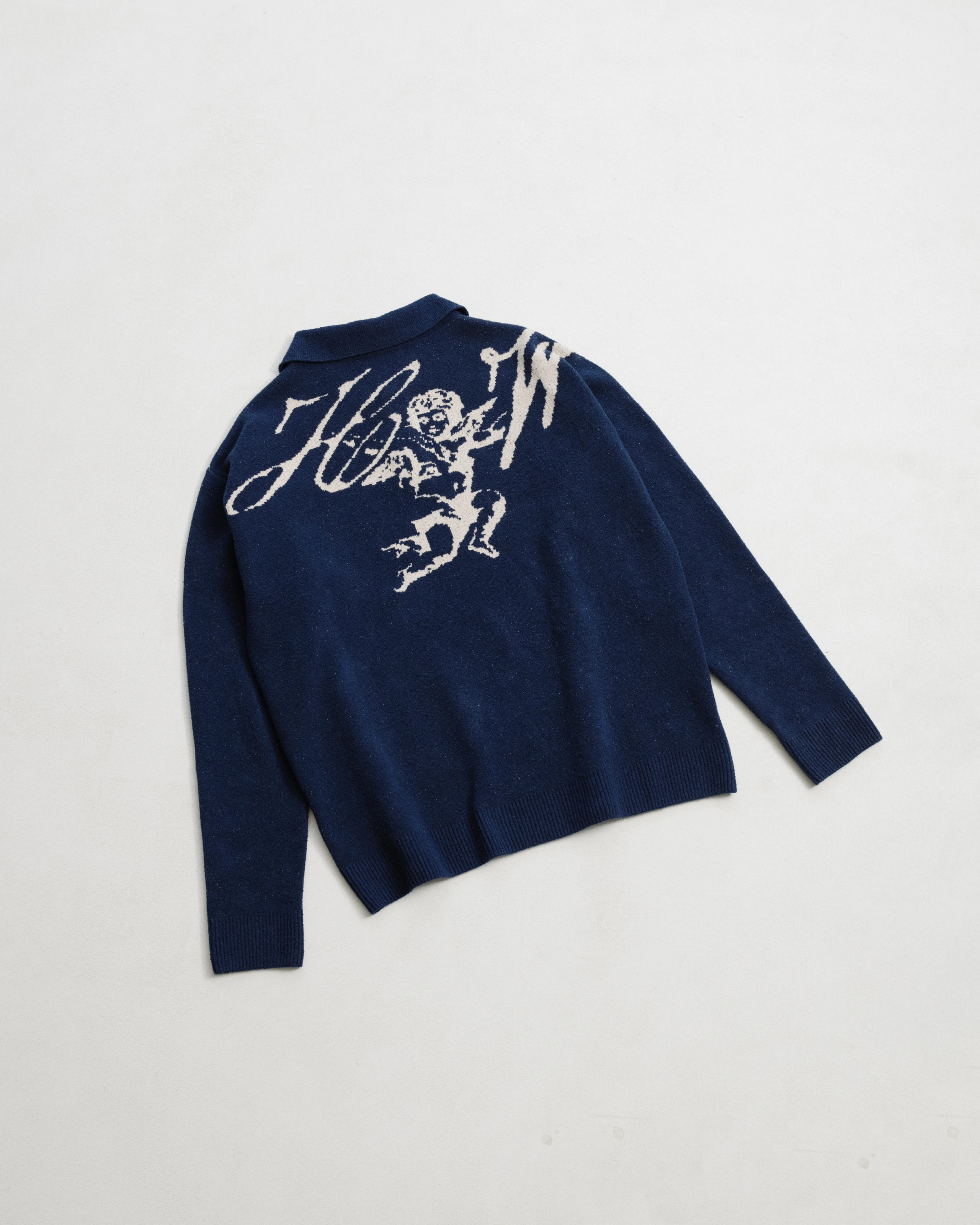 Back side of dark blue jacquard knitted sweater with beige graphics. 