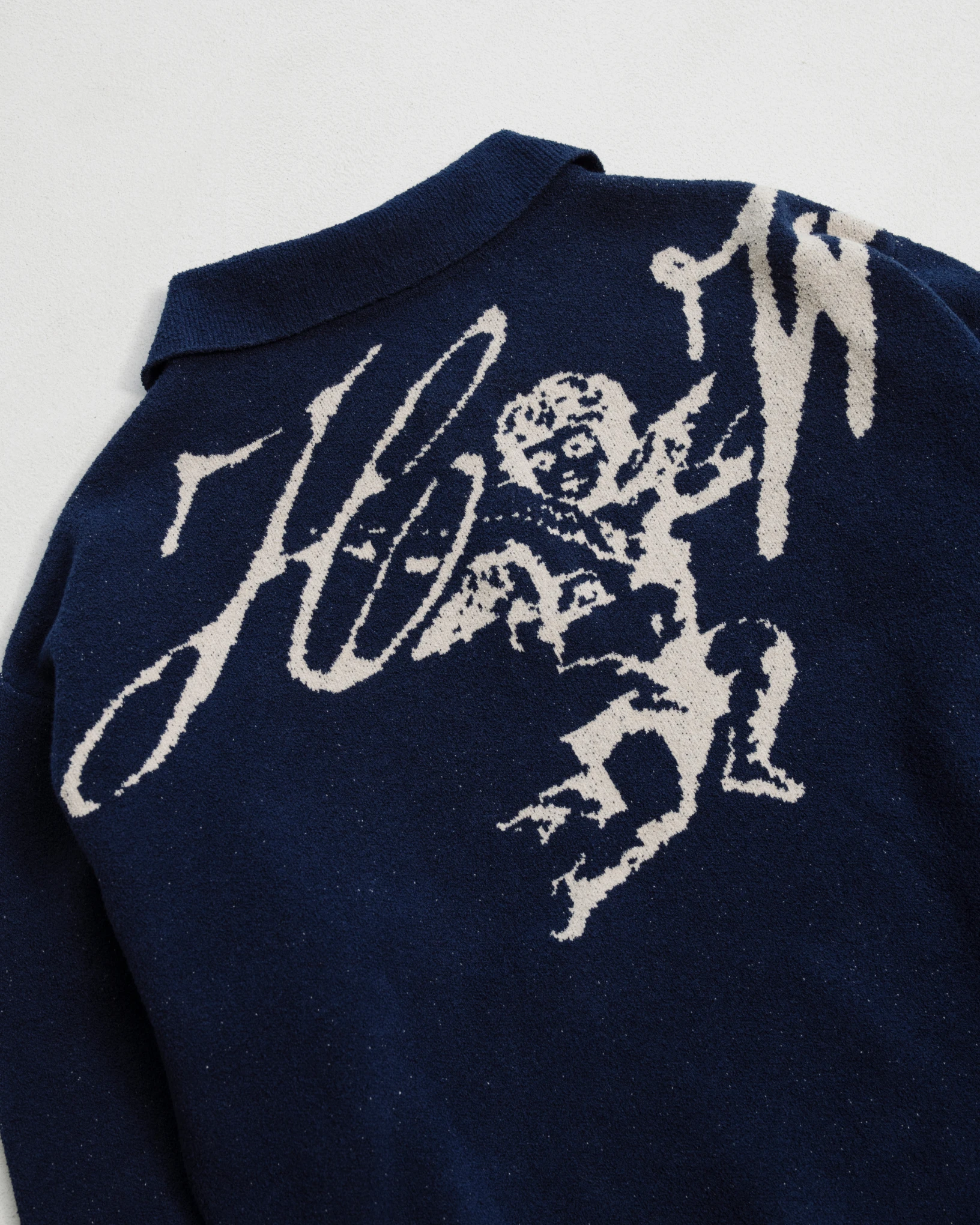 Dark blue jacquard knitted sweater with beige graphics. 