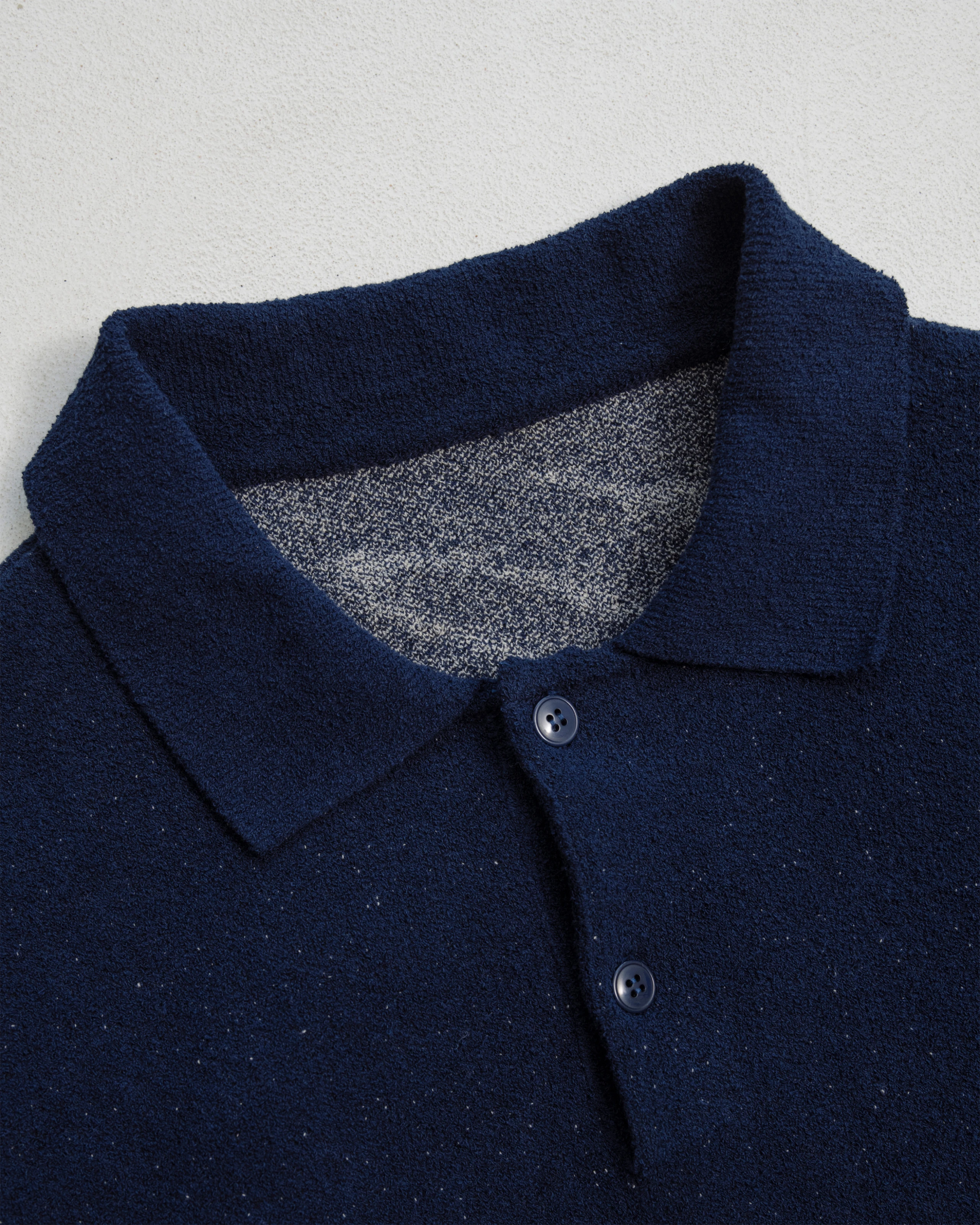 Collar detail of dark blue jacquard knitted sweater.
