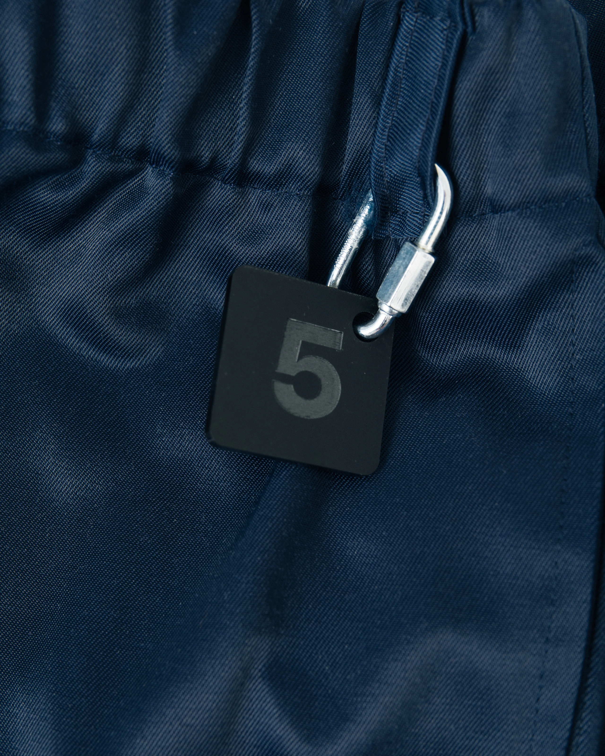 Blue work pants and number plate details from Kovari collection. 