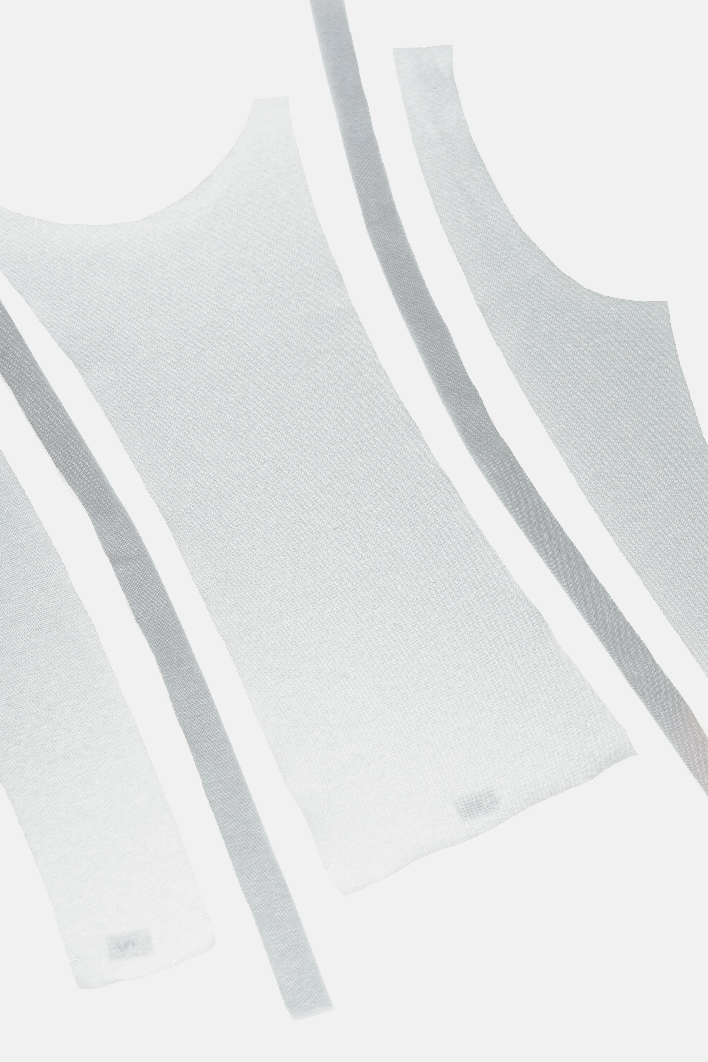 Close-up detail of knitted tank top pattern pieces showing tape finishing along the edges.